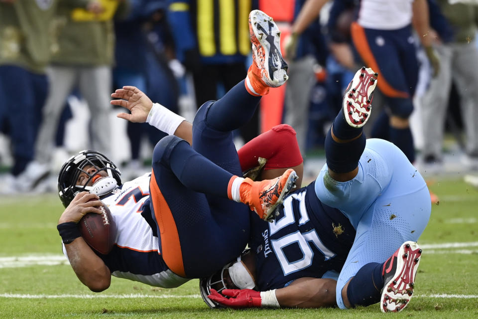 Tennessee Titans defensive end DeMarcus Walker (95) tackles Denver Broncos quarterback Russell Wilson (3) during the second half of an NFL football game, Sunday, Nov. 13, 2022, in Nashville, Tenn. (AP Photo/Mark Zaleski)