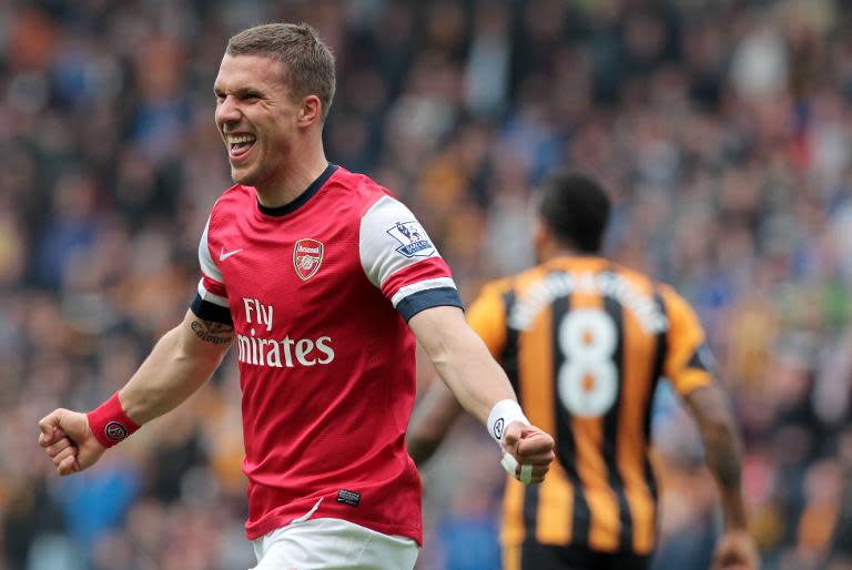 Arsenal's Lukas Podolski (L) celebrates after scoring his team's second goal against Hull City, at the KC Stadium in Hull, on April 20, 2014