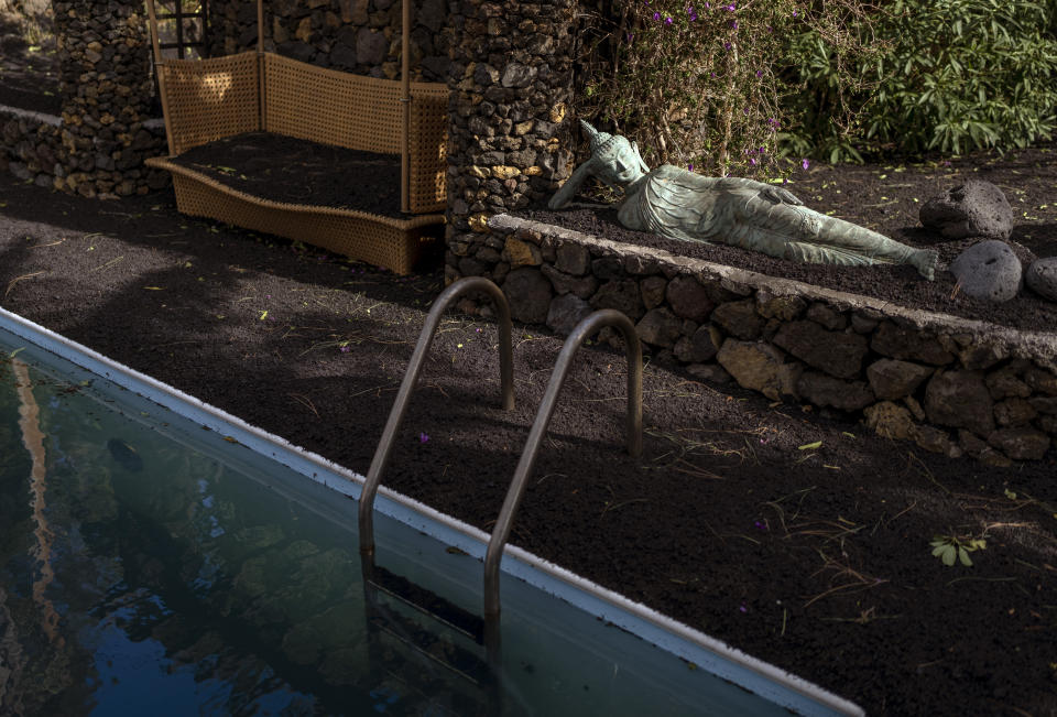 Debris covers the ground of a garden of a house near to where a volcano erupted near El Paso on the island of La Palma in the Canaries, Spain, Tuesday, Sept. 21, 2021. A dormant volcano on a small Spanish island in the Atlantic Ocean erupted on Sunday, forcing the evacuation of thousands of people. Huge plumes of black-and-white smoke shot out from a volcanic ridge where scientists had been monitoring the accumulation of molten lava below the surface. (AP Photo/Emilio Morenatti)