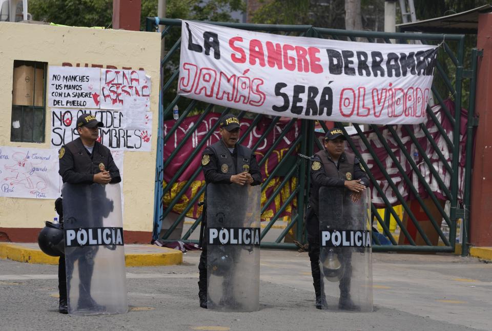 Policías antimotines hacen guardia a la entrada de la universidad de San Marcos University que alberga a las personas que viajaron a la capital peruana desde otras partes del país para unirse a las protestas contra el gobierno de la presidenta peruana Dina Boluarte' y el Congreso en Lima, Perú, el viernes 20 de enero de 2023. Las protestas buscan un adelanto electoral inmediato, la renuncia de Boluarte, la liberación del presidente destituido Pedro Castillo y justicia por los al menos 48 manifestantes muertos en enfrentamientos con la policía. (AP Foto/Martín Mejía)