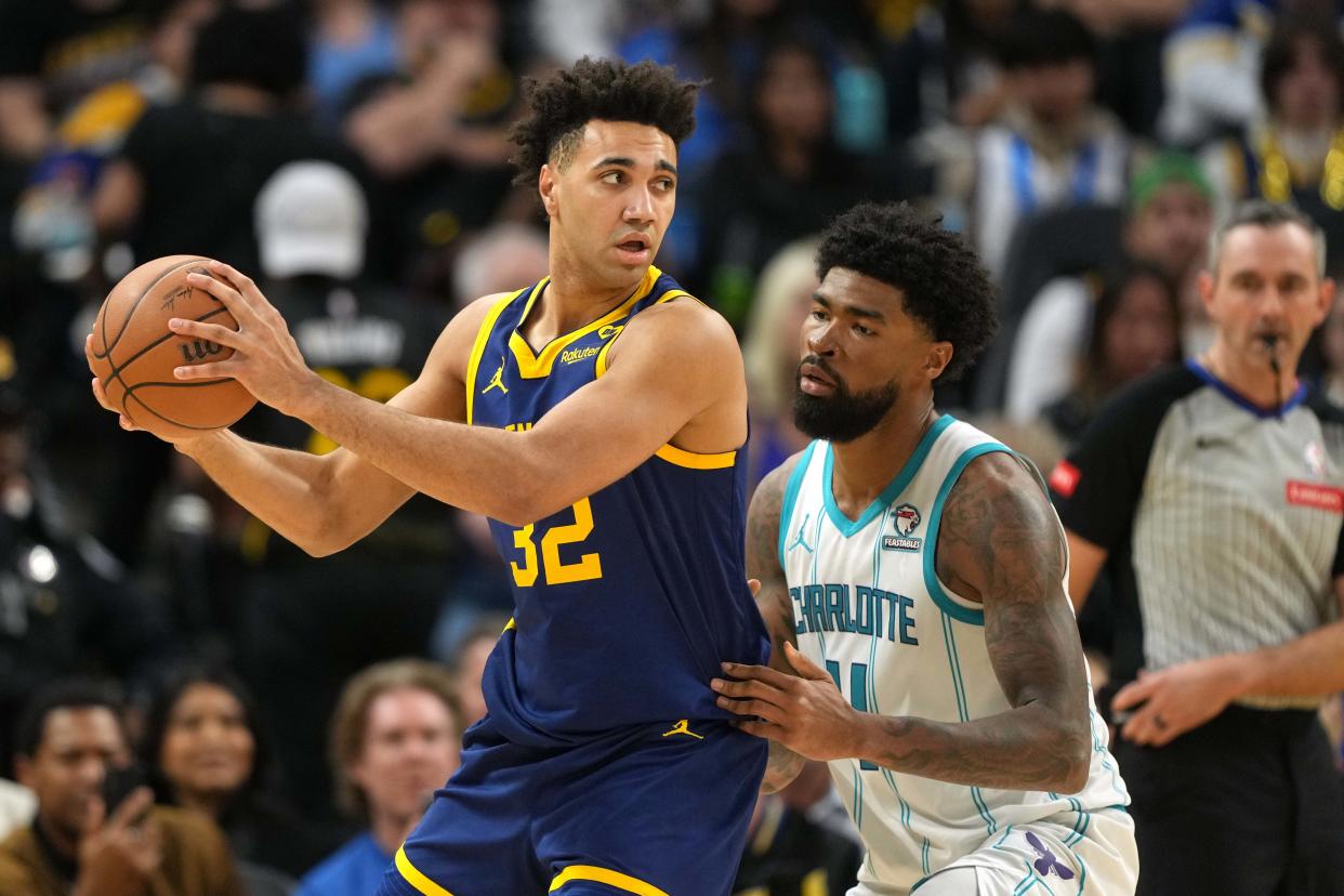 Feb 23, 2024; San Francisco, California, USA; Golden State Warriors forward Trayce Jackson-Davis (left) handles the ball against Charlotte Hornets center Nick Richards (right) during the fourth quarter at Chase Center. Mandatory Credit: Darren Yamashita-USA TODAY Sports