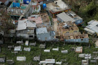 <p>The remains of damaged homes stand next to a cemetery as recovery efforts continue following Hurricane Maria in Morovis, Puerto Rico, Oct. 7, 2017. (Photo: Lucas Jackson/Reuters) </p>