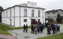 People gather outside the renovated synagogue in Wojslawice, Poland, on Thursday Oct. 14, 2021. A grave was dedicated Thursday in Wojslawice to some 60 Jews executed in the town during the Holocaust. It is only one of many mass grave sites to be discovered in recent years in Poland, which during World War II was occupied by Adolf Hitler’s forces. (AP Photo/Czarek Sokolowski)