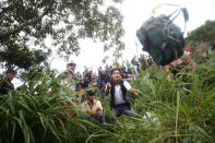 A Honduran migrant, part of a caravan trying to reach the U.S., throws a backpack after crossing the Suchiate river with the help of fellow migrants to avoid the border checkpoint in Ciudad Hidalgo, Mexico, October 19, 2018. REUTERS/Edgard Garrido