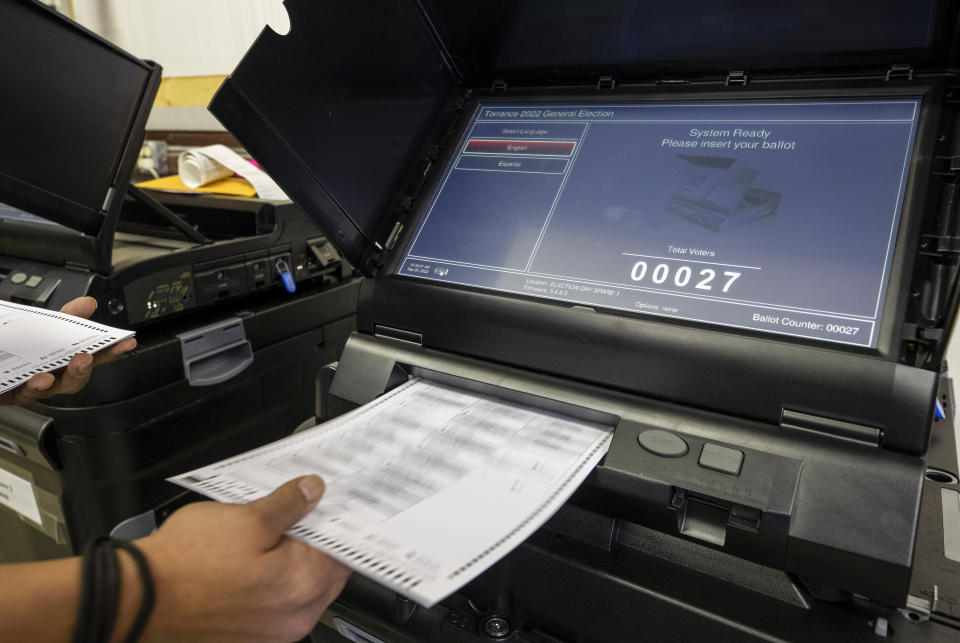 Torrance County administrative assistant clerk Kevin Pham introduces a ballot in a counting machine during a testing of election equipment with local candidates and partisan officers in Estancia, N.M., Sept. 29, 2022. (AP Photo/Andres Leighton)