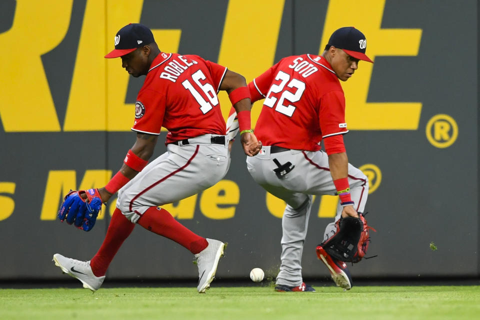 Washington Nationals center fielder Victor Robles (16) and left fielder Juan Soto both overrun a line drive by Atlanta Braves' Freddie Freeman during the seventh inning of a baseball game Sunday, July 21, 2019, in Atlanta. Ronald Acuna scored. (AP Photo/John Amis)