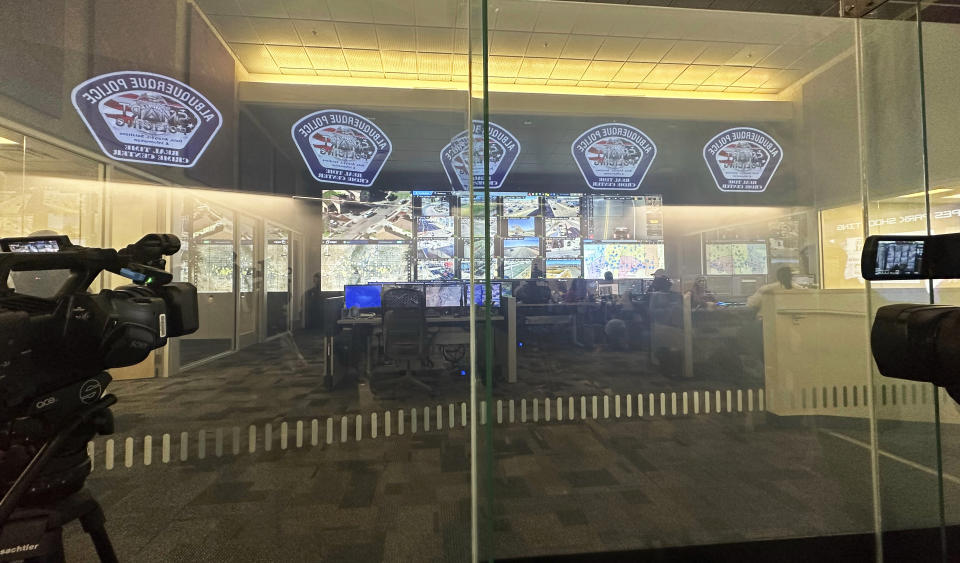 A wall of monitors behind a glass wall is pictured on Dec. 15, 2023, at the city's Real Time Crime Center in Albuquerque, N.M. Officials are seeking more funding from the New Mexico Legislature to add cameras and expand access to neighboring communities. (AP Photo/Susan Montoya Bryan)