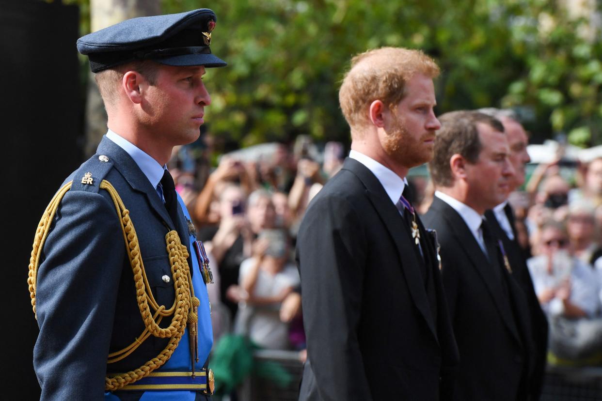 Britain's Prince William, Prince of Wales, Britain's Prince Harry, Duke of Sussex and Peter Phillips, walk behind the coffin of Queen Elizabeth II, adorned with a Royal Standard and the Imperial State Crown and pulled by a Gun Carriage of The King's Troop Royal Horse Artillery, during a procession from Buckingham Palace to the Palace of Westminster, in London on September 14, 2022. - Queen Elizabeth II will lie in state in Westminster Hall inside the Palace of Westminster, from Wednesday until a few hours before her funeral on Monday, with huge queues expected to file past her coffin to pay their respects. (Photo by Chris J Ratcliffe / POOL / AFP) (Photo by CHRIS J RATCLIFFE/POOL/AFP via Getty Images)