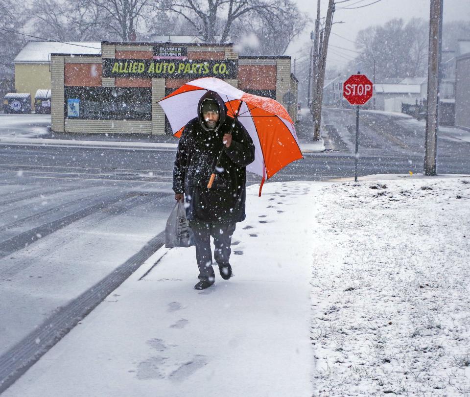 Jamal Roger of Randolph was ready for either snow or rain and brought his umbrella with him when he walked to a local store to get a few items on Tuesday, Feb. 13, 2024.