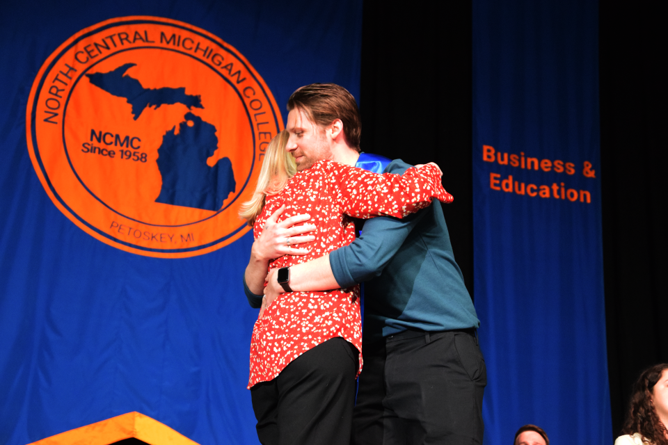 Charles Beck hugs his mom during the 2024 nurse pinning ceremony at North Central Michigan College.