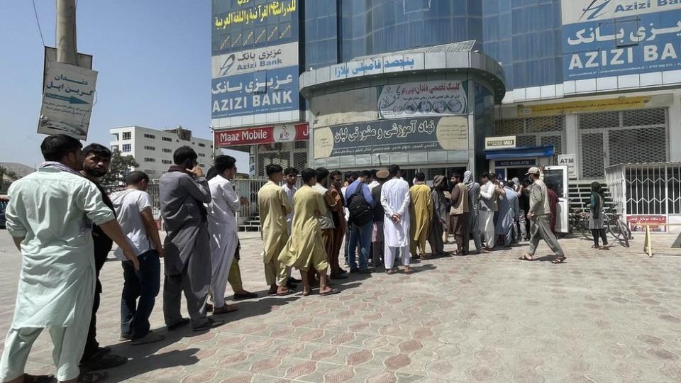 Afaganos fuera de un banco en Kabul