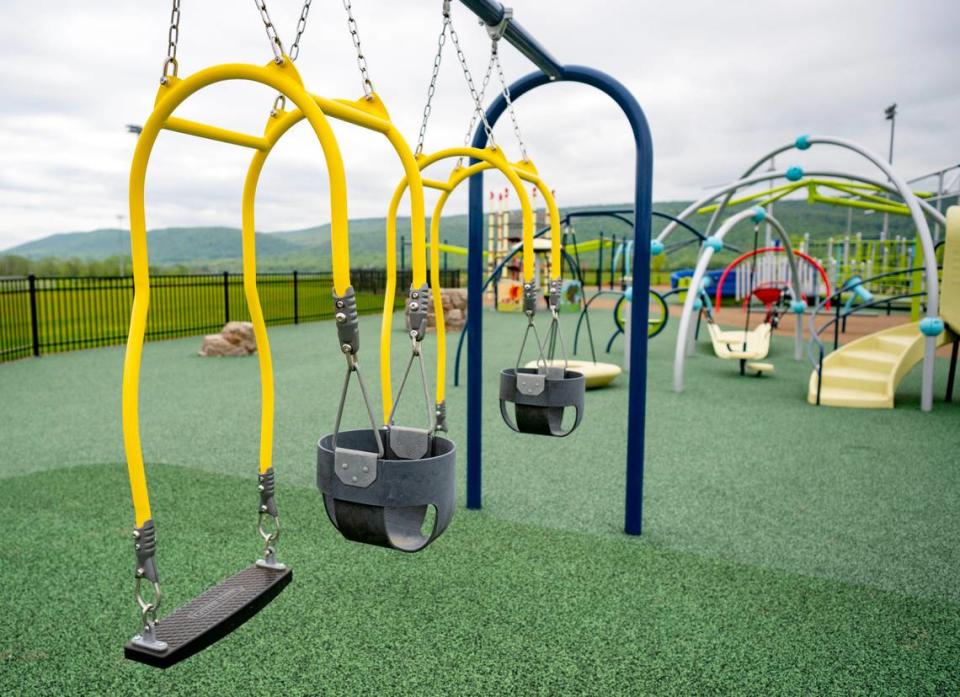 Swings for an adult and a child to swing together at the all-abilities playground at Whitehall Road Regional Park.