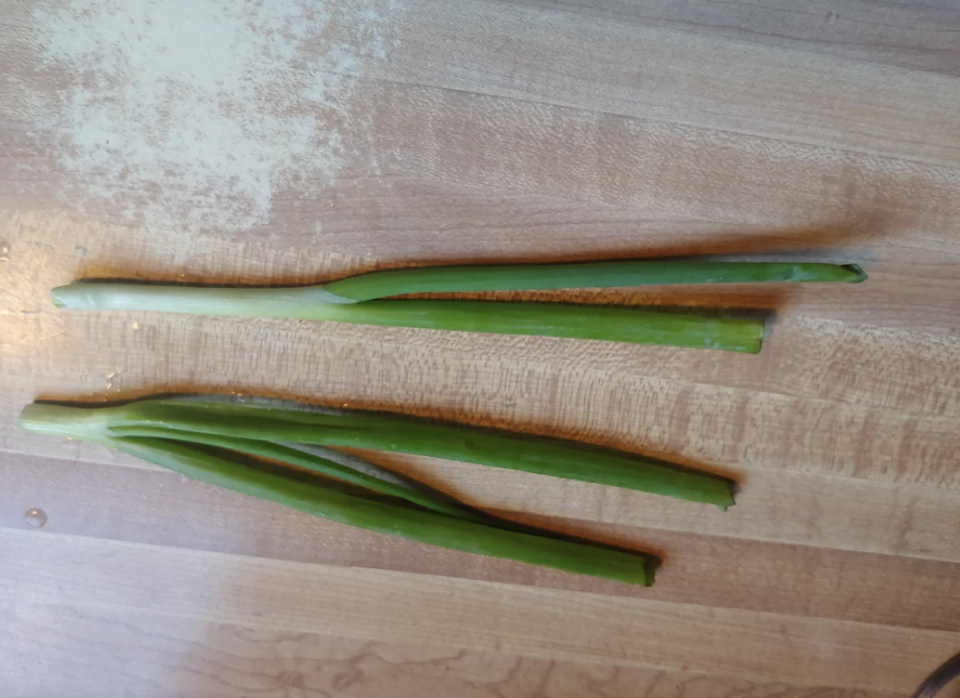 Aloe vera leaves on a wooden surface, with one leaf cut open to show the gel inside