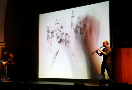 Kinan Azmeh plays the clarinet as Kevork does live sketching during their performance in Beirut, Lebanon March 26, 2018. REUTERS/Mohamed Azakir