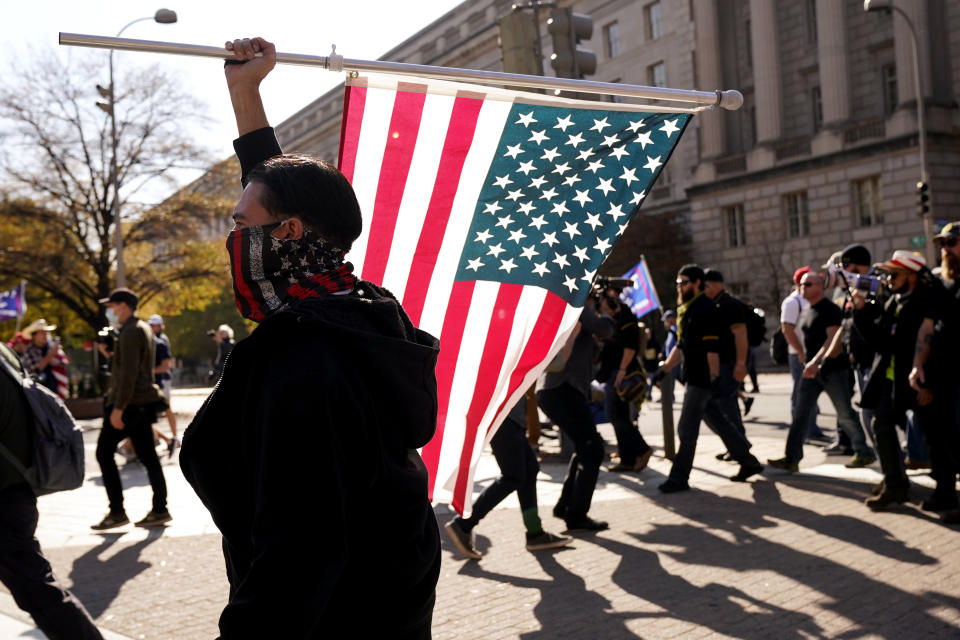 People wearing pro- Proud Boys clothing march down Pennsylvania Avenue with supporters of President Donald Trump, Saturday Nov. 14, 2020, in Washington. (AP Photo/Jacquelyn Martin)