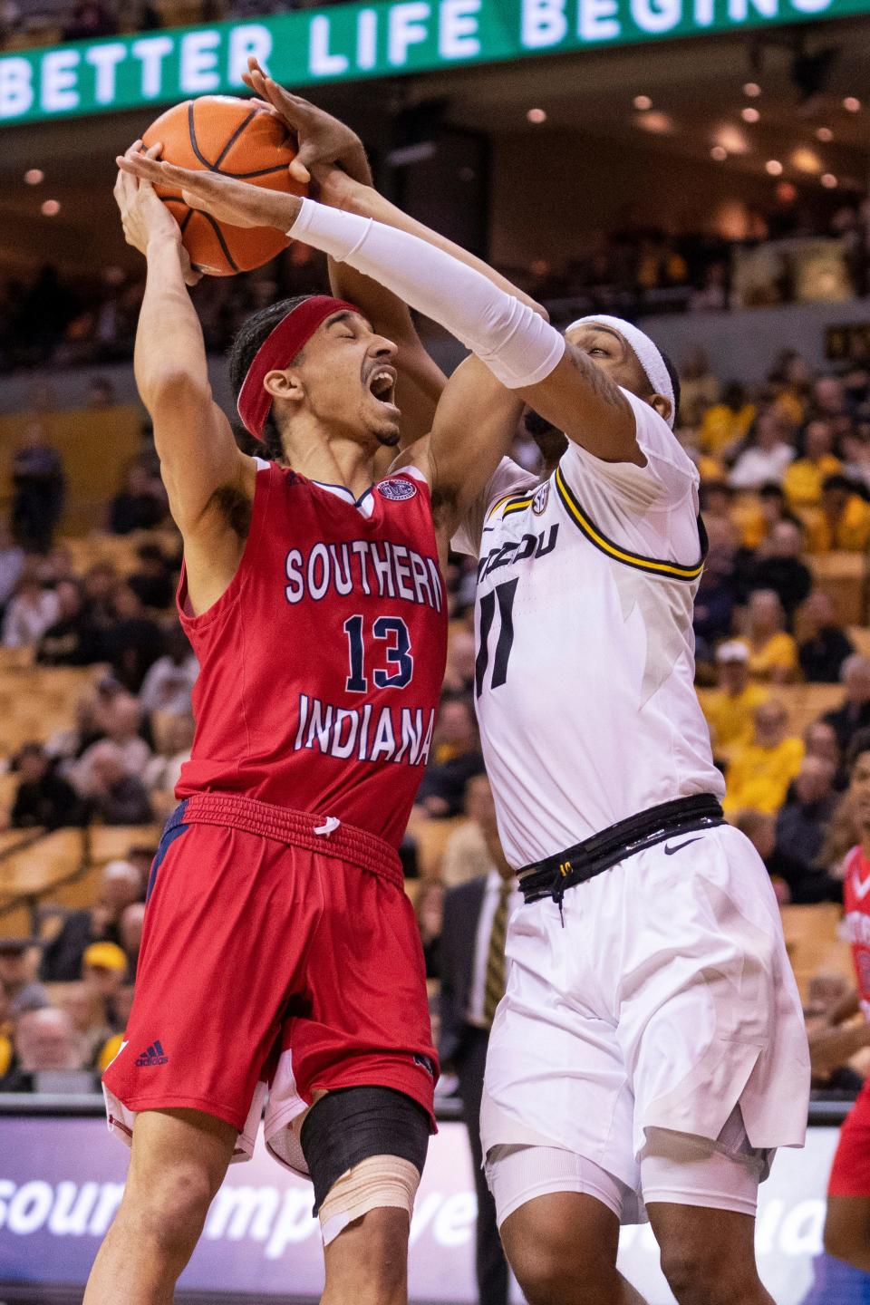 Southern Indiana's Jeremiah Hernandez, left, is fouled by Missouri's Isiaih Mosley, right, during the first half of an NCAA college basketball game Saturday, Nov. 7, 2022, in Columbia, Mo. Missouri won 97-91.