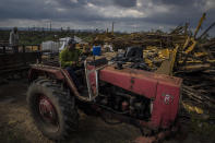 Tobacco farmer Hirochi Robaina drives his tractor past destroyed tobacco barns on his farm one week after Hurricane Ian in San Luis, in Pinar del Rio province, Cuba, Wednesday, Oct. 5, 2022 (AP Photo/Ramon Espinosa)