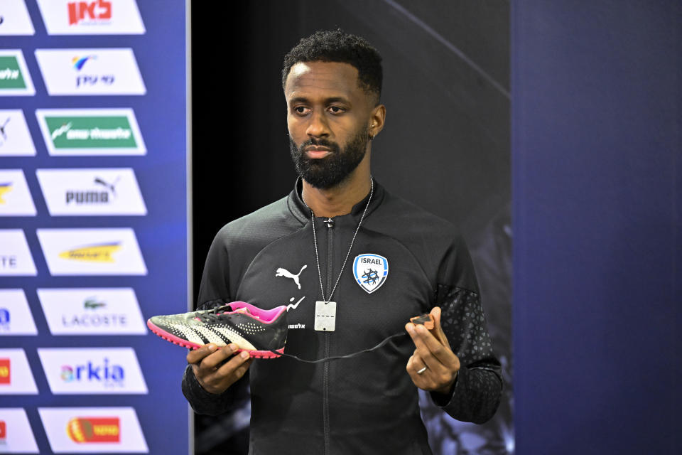 Israel team captain Eli Dasa shows a shoe of a kidnapped Israeli boy during a press conference, before a training session for the Euro 2024 group I qualifying soccer match between Israel and Switzerland at the Pancho Arena in Felcsút, Hungary, Tuesday, Nov. 14, 2023. The captain of Israel's soccer team on Tuesday displayed the shoe of a young boy that he said was kidnapped by Hamas militants during their deadly Oct. 7 raid, an act of solidarity with those Israelis still being held captive in the Gaza Strip ahead of the team's Wednesday game in Hungary. (AP Photo/Denes Erdos)