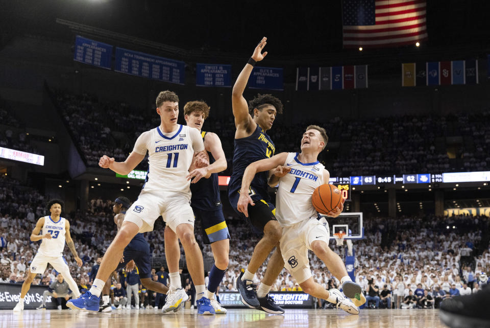 Creighton's Steven Ashworth, right, drives against Marquette's Stevie Mitchell, second right, as Creighton's Ryan Kalkbrenner, left, blocks Marquette's Ben Gold, second left, during the second half of an NCAA college basketball game Saturday, March 2, 2024, in Omaha, Neb. Creighton defeated Marquette 89-75. (AP Photo/Rebecca S. Gratz)