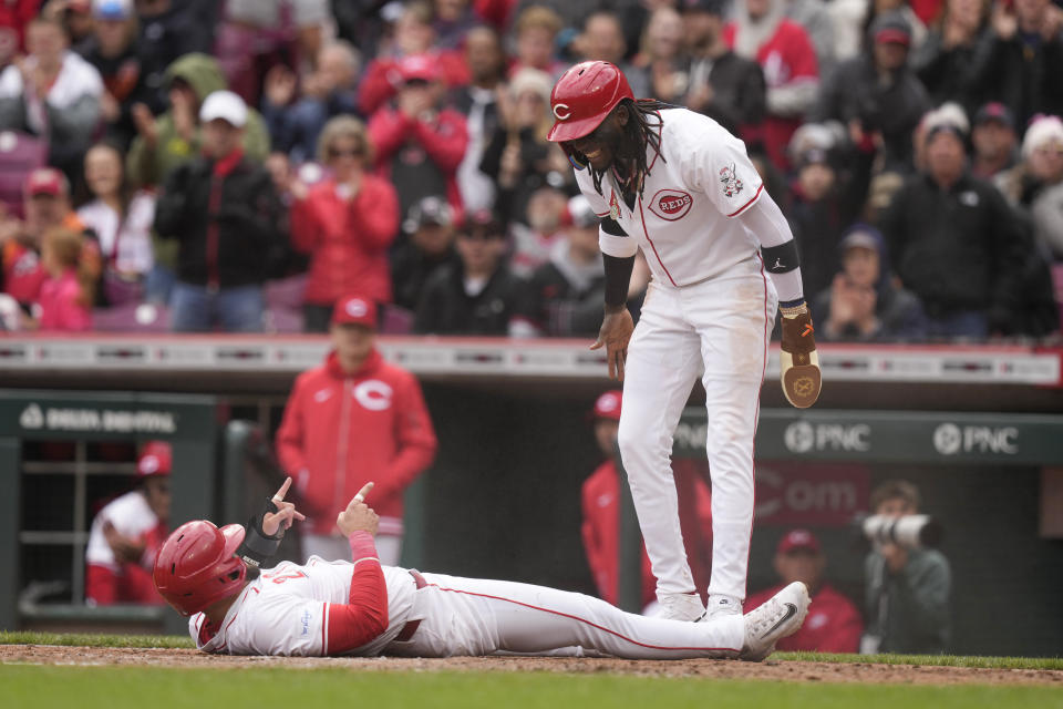 Cincinnati Reds' Elly De La Cruz, right, and Reds designated hitter Nick Martini, left, celebrate after they scored off Christian Encarnacion-Strand's double in the sixth inning of a baseball game against the Los Angeles Angels, Sunday, April 21, 2024, in Cincinnati. (AP Photo/Carolyn Kaster)