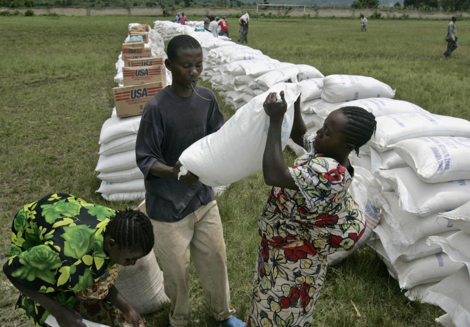 In this Nov. 14, 2008, file photo, a woman receives a bag of maize meal from the World Food Program in the town of Rutshuru, eastern Congo. The World Food Program chief warned Thursday, Sept. 17, 2020, that millions of people are closer to starvation because of the deadly combination of conflict, climate change and the COVID-19 pandemic and he urged donor nations and billionaires to help feed them and ensure their survival. (AP Photo/Karel Prinsloo)