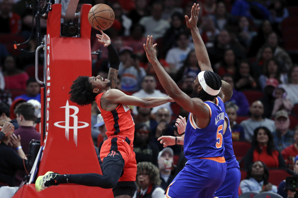 Houston Rockets guard Jalen Green, left, flips up the ball in front of New York Knicks forward Precious Achiuwa (5) and guard Donte DiVincenzo, right, during the first half of an NBA basketball game Monday, Feb. 12, 2024, in Houston. (AP Photo/Michael Wyke)