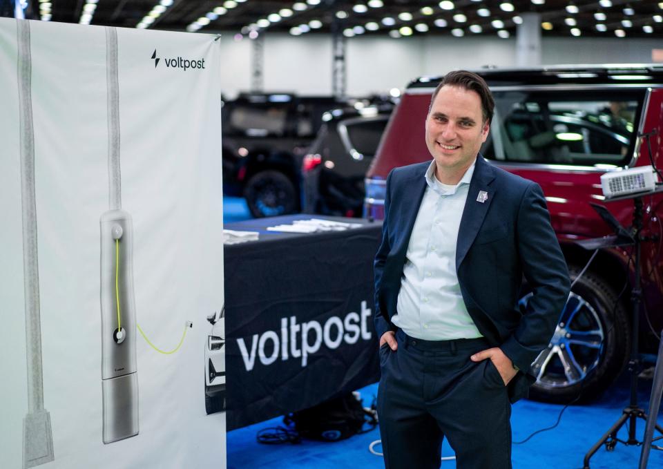 Voltpost Founder and CEO Jeff Prosserman stands near a photo of his charging station for electric vehicles during the 2023 North American International Auto Show held at Huntington Place in downtown Detroit on Thursday, Sept. 14, 2023.