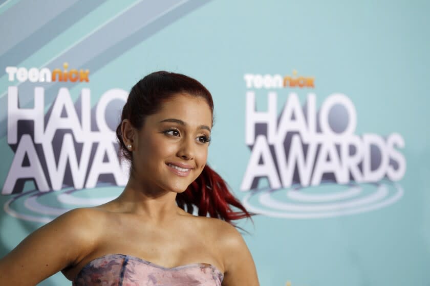 A teenage girl with red hair in a ponytail smiling against a blue backdrop that reads "Teen Nick Halo Awards"