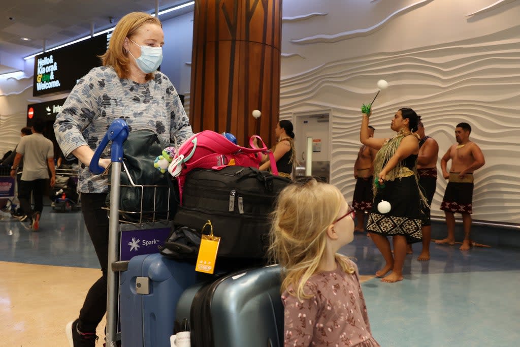 Tourists, friends and family are welcomed to Auckland International Airport on 13 April as New Zealand re-opened borders to Australians  (Getty)