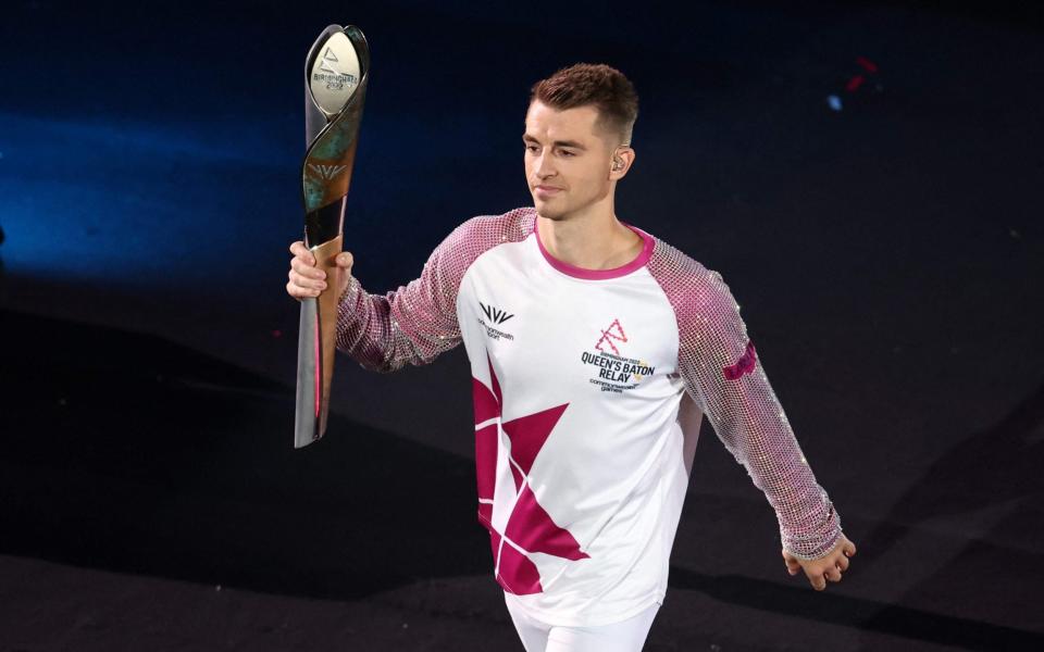 Batonbearer England's Max Whitlock carries the the Queen's Baton during the opening ceremony for the Commonwealth Games - AFP
