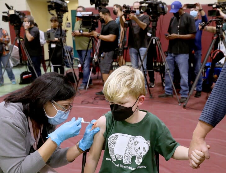 Felix Johnstone, 7, of Altadena, with mother Caitlin Johnstone, right, receives a child's dose of the Pfizer vaccination.