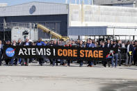 Workers and contractors who worked on the core stage of NASA's Space Launch System rocket, that will be used for the Artemis 1 Mission, follow the rocket as it is transported to the Pegasus barge at the NASA Michoud Assembly Facility where it was built, in New Orleans, Wednesday, Jan. 8, 2020. It will be transported to NASA's Stennis Space Center in Mississippi for its green run test. (AP Photo/Gerald Herbert)