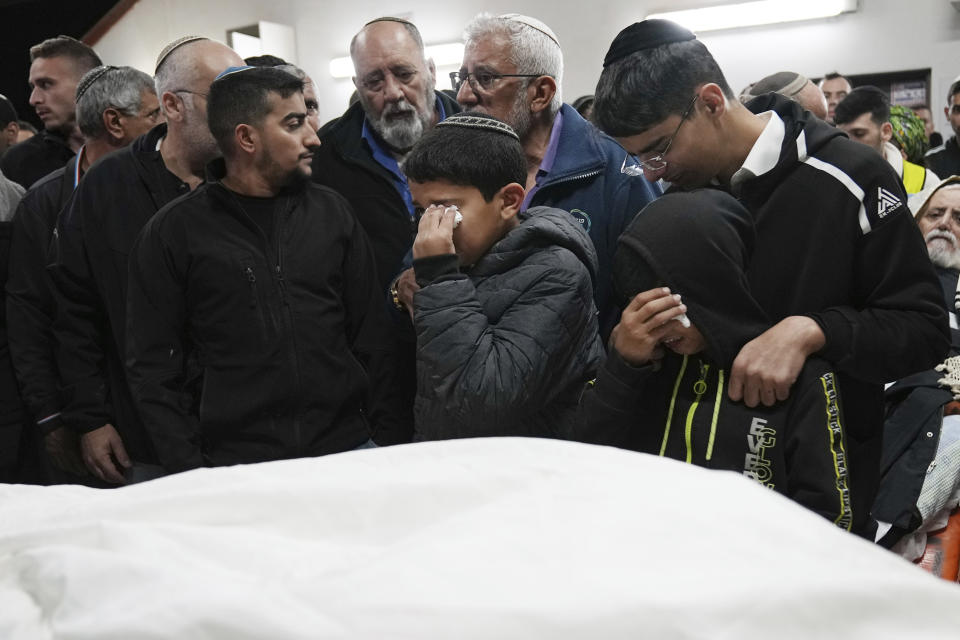 Boys weep at the funeral for their father, Tamir Avihai, 50, in the West Bank Israeli settlement of Barkan, Tuesday, Nov. 15, 2022. A Palestinian killed three Israelis, including Avihai and wounded three others in an attack in a settlement in the occupied West Bank on Tuesday before he was shot and killed by Israeli security personnel, Israeli paramedics and Palestinian officials said. (AP Photo/ Tsafrir Abayov)