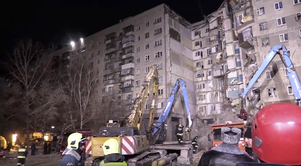 This photo provided by the Russian Emergency Situations Ministry taken from tv footage shows Emergency Situations employees work at the scene of a collapsed section of an apartment building, in Magnitigorsk, a city of 400,000 about 1,400 kilometers (870 miles) southeast of Moscow, Russia, Wednesday, Jan. 2, 2019. Search crews have pulled more bodies from a huge pile of rubble at a collapsed Russian apartment building. (Russian Ministry for Emergency Situations photo via AP)