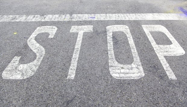 Stop sign on asphalt, detail of a traffic signal, security and prohibition