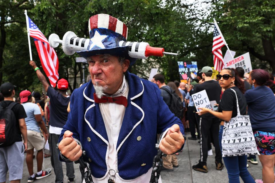 People gather at City Hall in New York City to protest vaccine mandates after Mayor Bill de Blasio announced last week that proof of coronavirus vaccination will be required to attend indoor restaurants, gyms and entertainment venues.