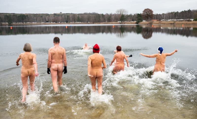 Naked swimmers run into Hanover's Sonnensee lake during the 7th New Year's nude swim organized by one of the largest naturist clubs in Germany, which has some 1,500 members. Julian Stratenschulte/dpa