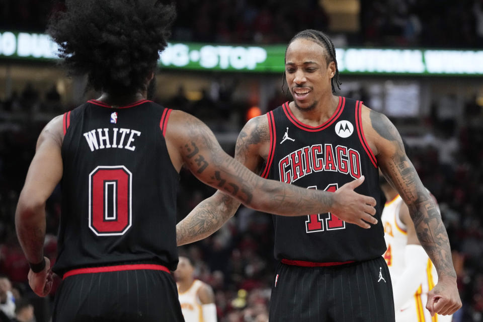 Chicago Bulls guard Coby White, left, celebrates with forward DeMar DeRozan after scoring against the Atlanta Hawks during the second half of an NBA basketball play-in tournament game in Chicago, Wednesday, April 17, 2024. The Bulls won 131-116. (AP Photo/Nam Y. Huh)