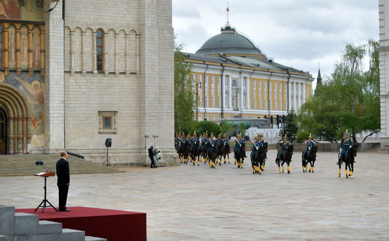 Russian President Putin watches honour guards riding horses in Cathedral Square at the Kremlin during the celebrations of Victory Day in central Moscow