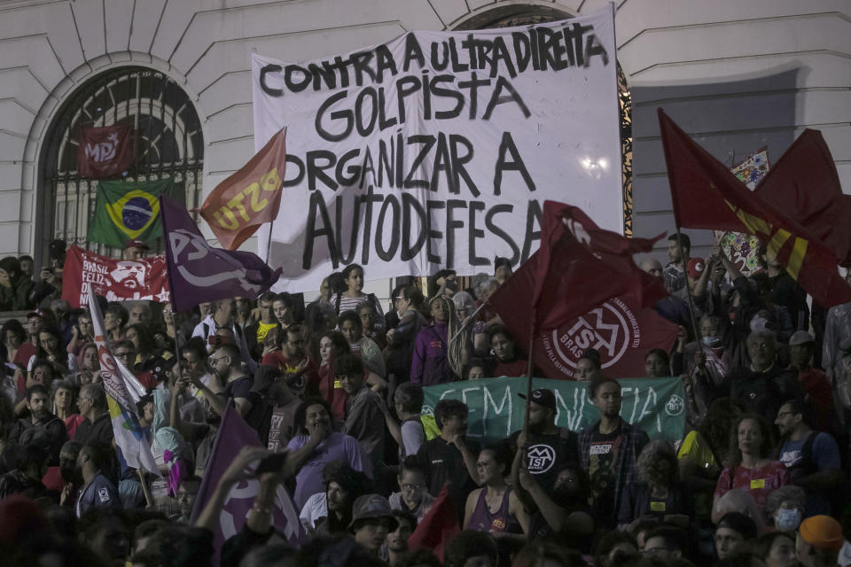Protesters hold a sign that reads in Portuguese:"Against the ultra right putsch to organize self-defense" during an act in favor of Brazilian democracy in Rio de Janeiro, Brazil, Monday, Jan. 9, 2023, one day after supporters of former President Jair Bolsonaro stormed government buildings in the capital city of Brasilia. (AP Photo/Bruna Prado)