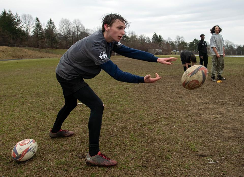 WORCESTER - Worcester Tech senior Braedon McCormick tosses the ball during a drill at rugby practice Thursday, March 21, 2024.