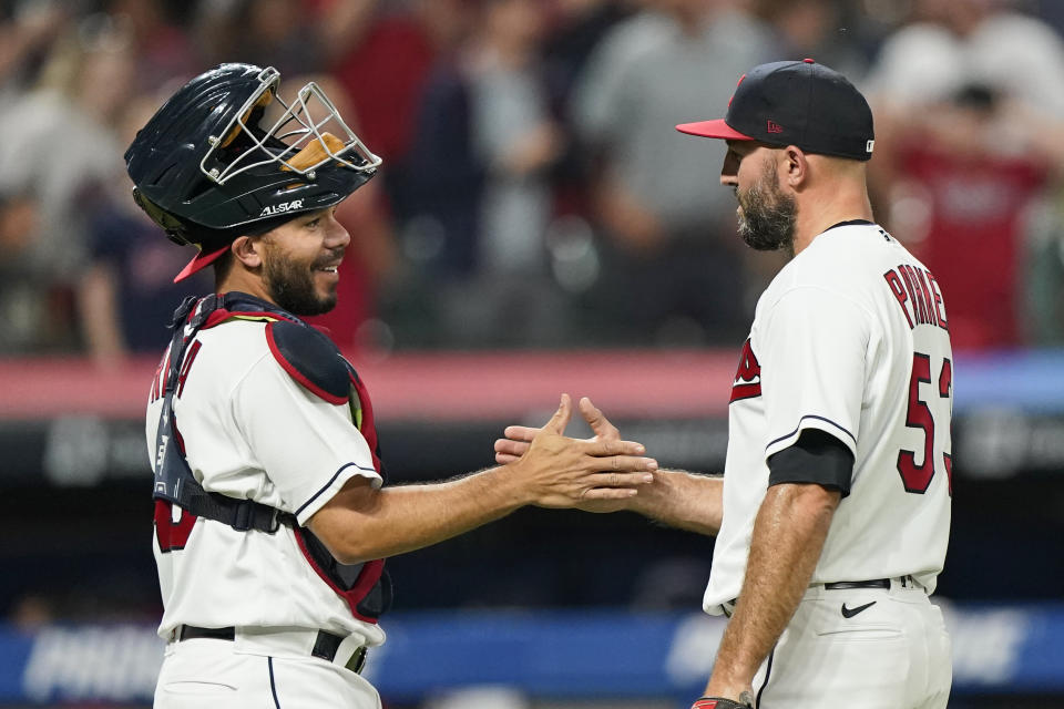 Cleveland Indians relief pitcher Blake Parker, right, is congratulated by catcher Rene Rivera after the Indians defeated the Seattle Mariners 7-0 in a baseball game Friday, June 11, 2021, in Cleveland. (AP Photo/Tony Dejak)