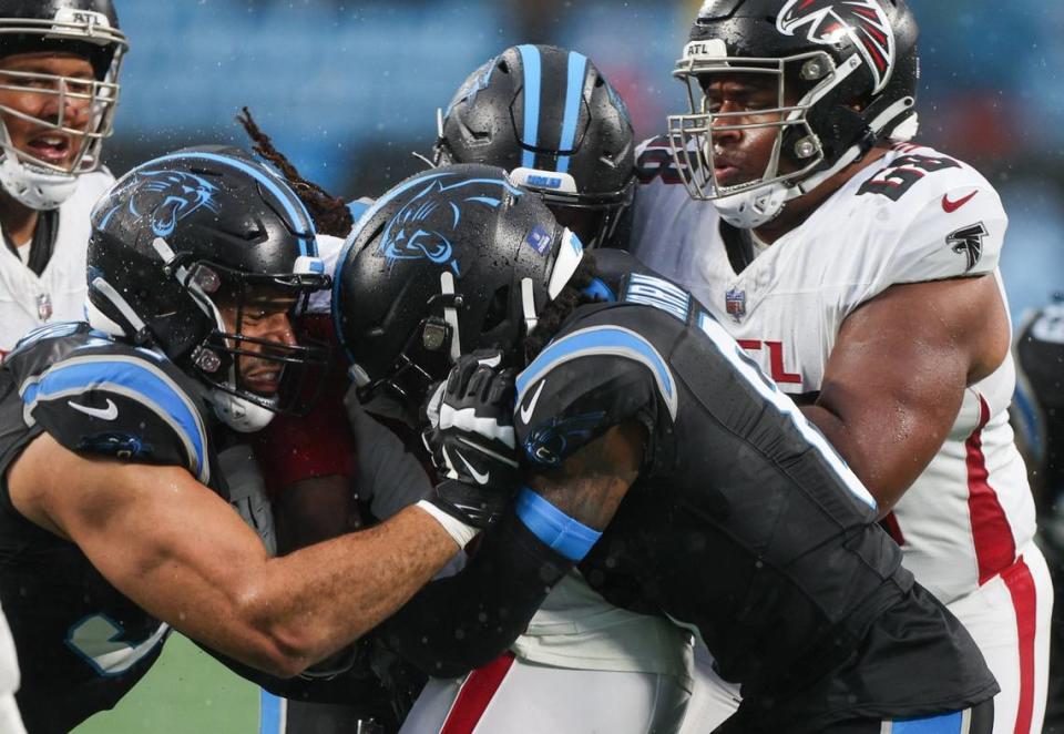 Panthers defensive end Chris Wormley, left, and cornerback Jaycee Horn doubleteam a tackle against the Falcons during the game at Bank of America Stadium on Sunday, December 16, 2023.