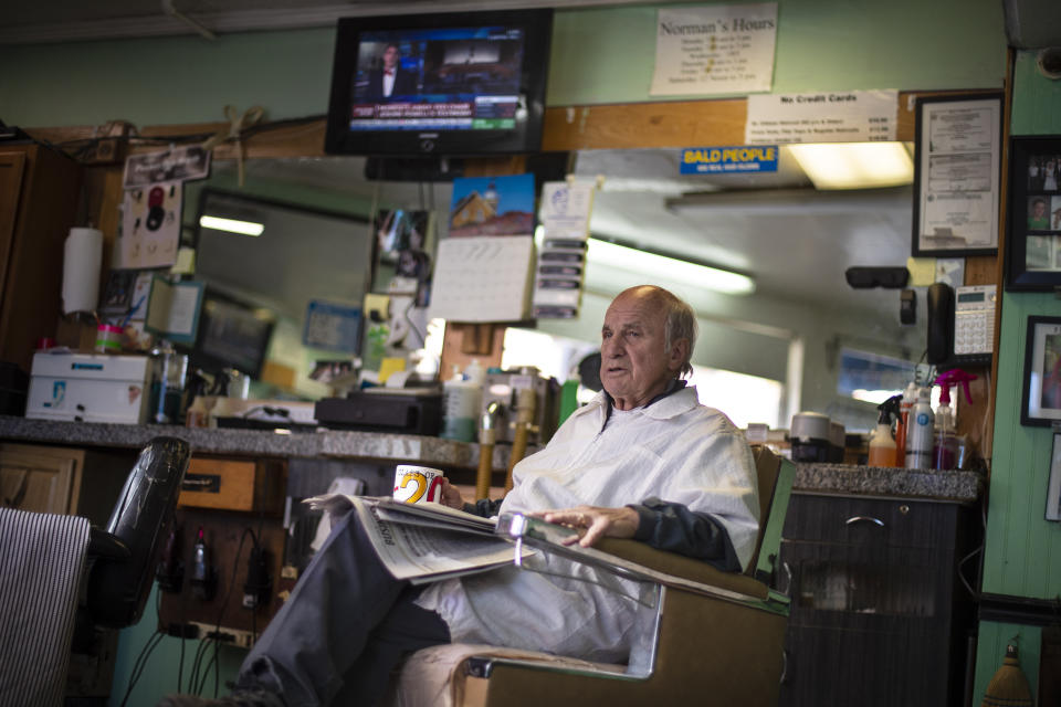 Barber Dick Stetson, 81, waits for a customer, Wednesday, Nov. 13, 2019, in Portland, Maine. Stetson said he had little interest in the impeachment hearings, switching his TV to a financial channel. "The hearing won't effect me, I'm a barber." he said. (AP Photo/Robert F. Bukaty)