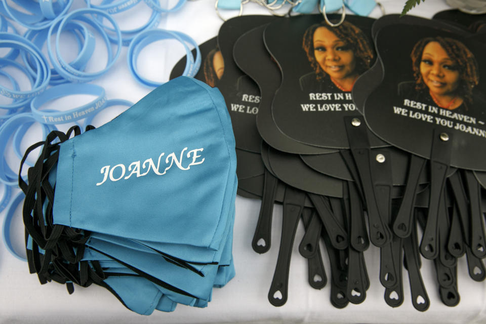 Commemorative fans and wrist bands are joined by face masks in honor of Joanne Paylor, 62, of southwest Washington, during her funeral at Cedar Hill Cemetery in Suitland-Silver Hill, Md., Sunday, May 3, 2020. The original funeral for Paylor, who the family believes died of a heart attack, was delayed for close to two months while her family hoped social distancing guidelines would be lifted. When it became clear it would not they were able to arrange a viewing with only ten people cycling inside at a time from 6 feet apart and an outdoor memorial service. Despite not having died from coronavirus, almost every aspect of her funeral has been impacted by the pandemic. (AP Photo/Jacquelyn Martin)