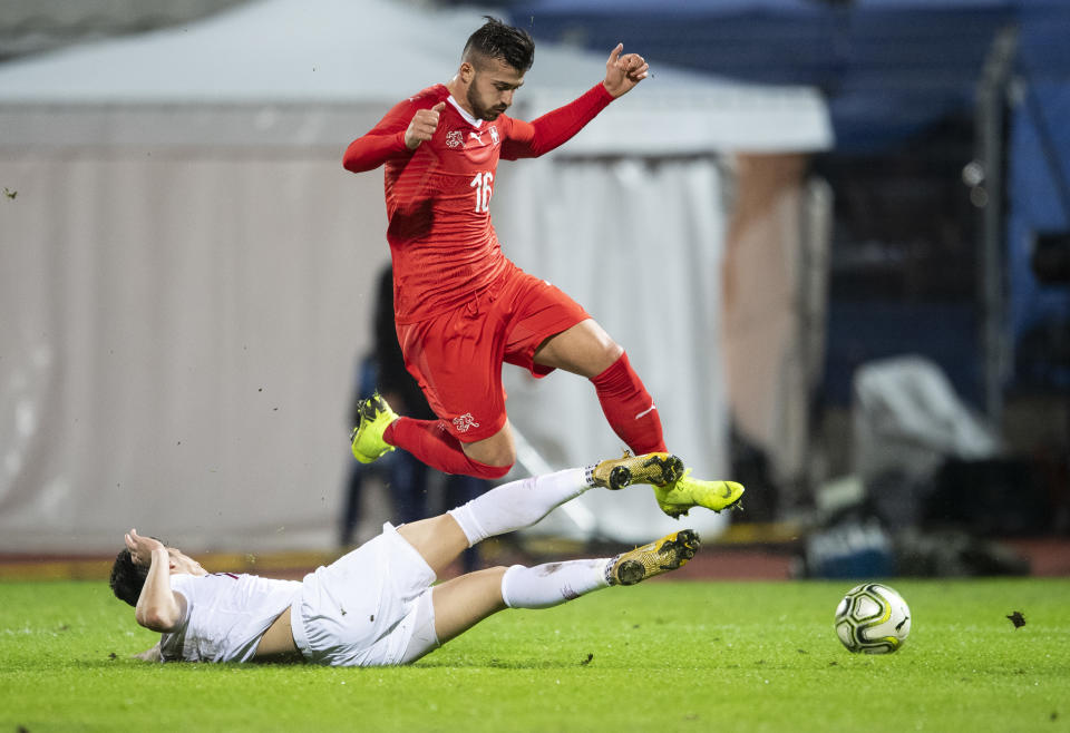 Qatar's Bassam Hisham, left, tackles Switzerland's Albian Ajeti during an international friendly soccer match between Switzerland and Qatar at the Cornaredo stadium in Lugano, Switzerland, Wednesday, Nov. 14, 2018. (Ennio Leanza/Keystone via AP)