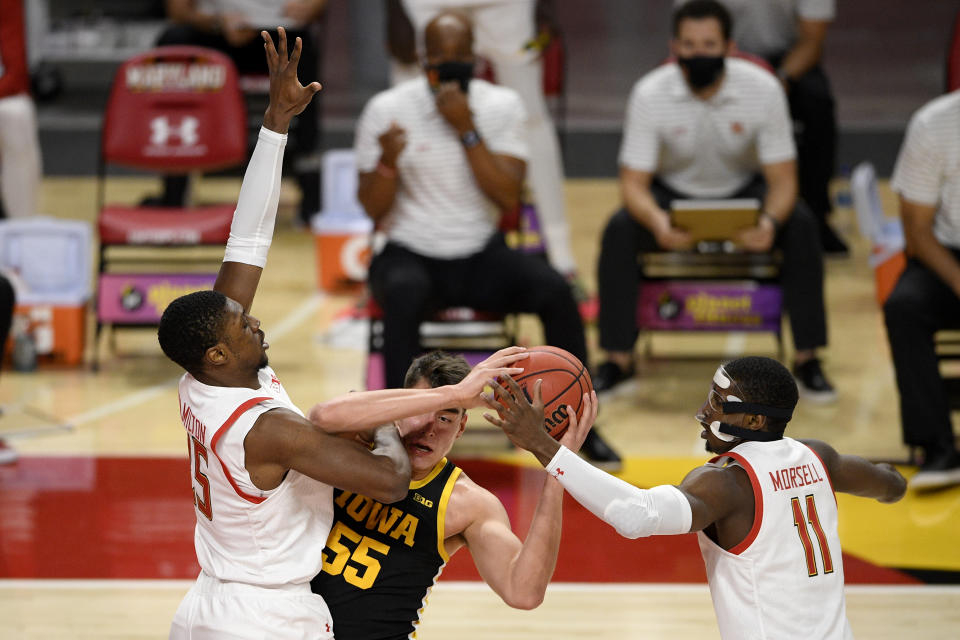 Maryland guard Darryl Morsell (11) and forward Jairus Hamilton, left, battle for the ball with Iowa center Luka Garza (55) during the first half of an NCAA college basketball game, Thursday, Jan. 7, 2021, in College Park, Md. (AP Photo/Nick Wass)