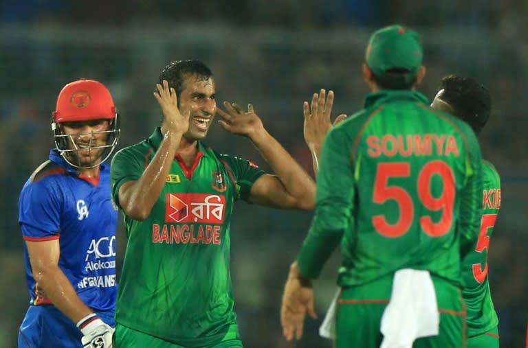 Bangladesh cricketers congratulate teammate Mosharraf Hossain(C) after the dismissal of Afghanistan cricketer Nawroz Mangal during their third one day international cricket match the Sher-e-Bangla National Cricket Stadium in Dhaka on October 1, 2016