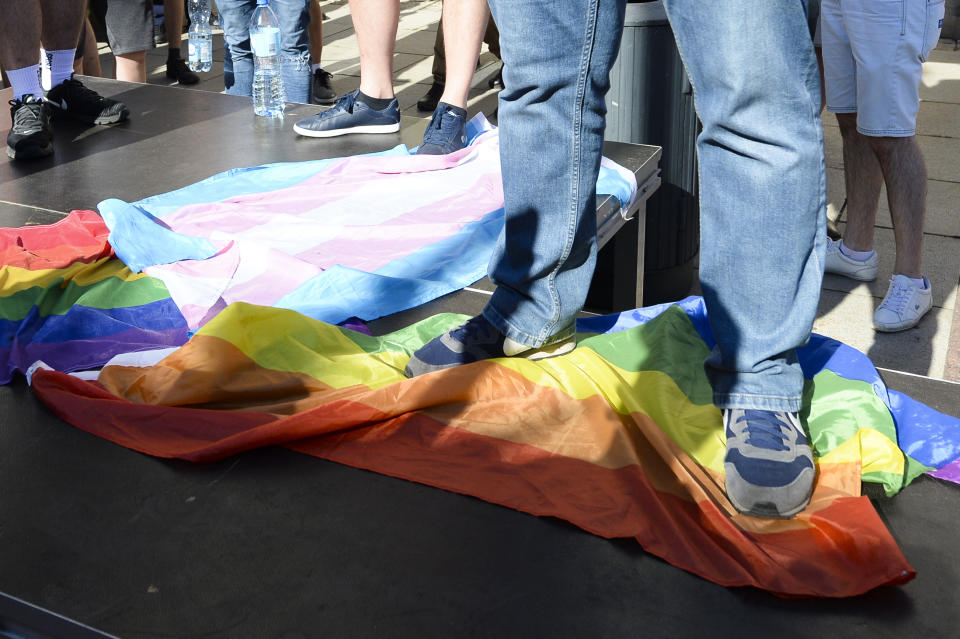 FILE - In This Sunday, Aug. 16, 2020 fie photo, a man stands on a Rainbow Flag as he attends a demonstration of far-right activists against LGBT rights in Warsaw, Poland. Ambassadors to Poland from some 50 countries and international organizations have expressed their support with an open letter published Sunday, for the LGBT community in the country. (Photo/Czarek Sokolowski)