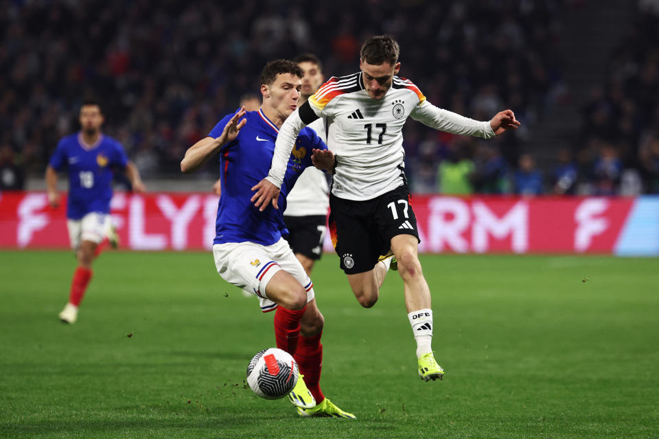 France's defender #02 Benjamin Pavard (L) and Germany's midfielder #17 Florian Wirtz (R) fight for the ball during the friendly football match between France and Germany, at the Groupama Stadium in Decines-Charpieu, near Lyon, on March 23, 2024. (Photo by FRANCK FIFE / AFP) (Photo by FRANCK FIFE/AFP via Getty Images)